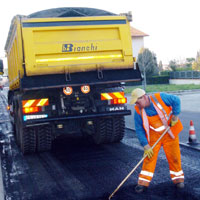 operaio al lavoro di asfaltatura di strada